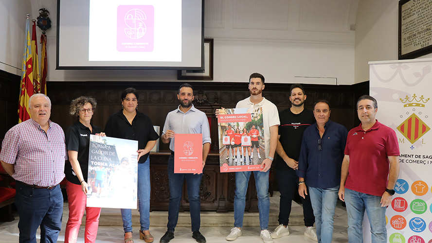 Vicky Sevilla y las jugadoras y jugadores de los equipos de balonmano de la ciudad, con el comercio de Sagunto